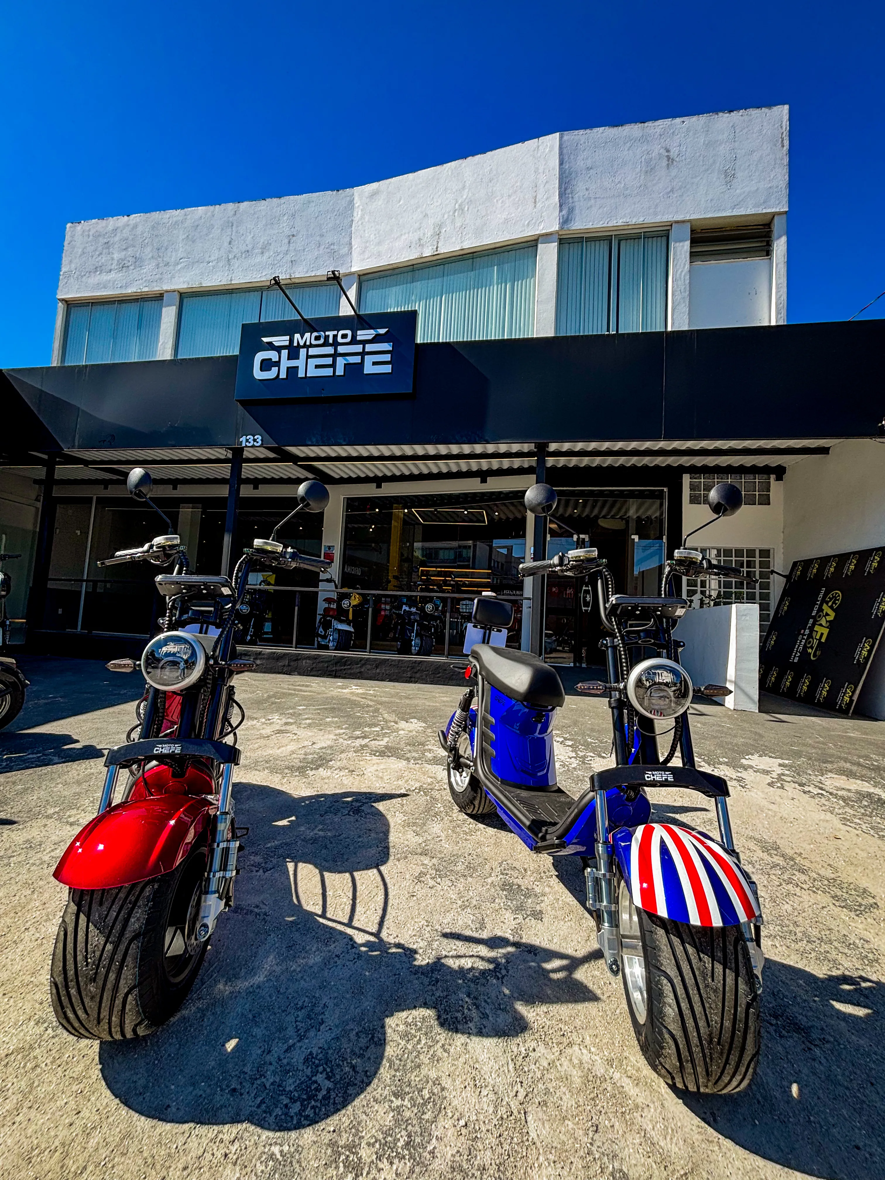 Três scooters elétricos na fachada